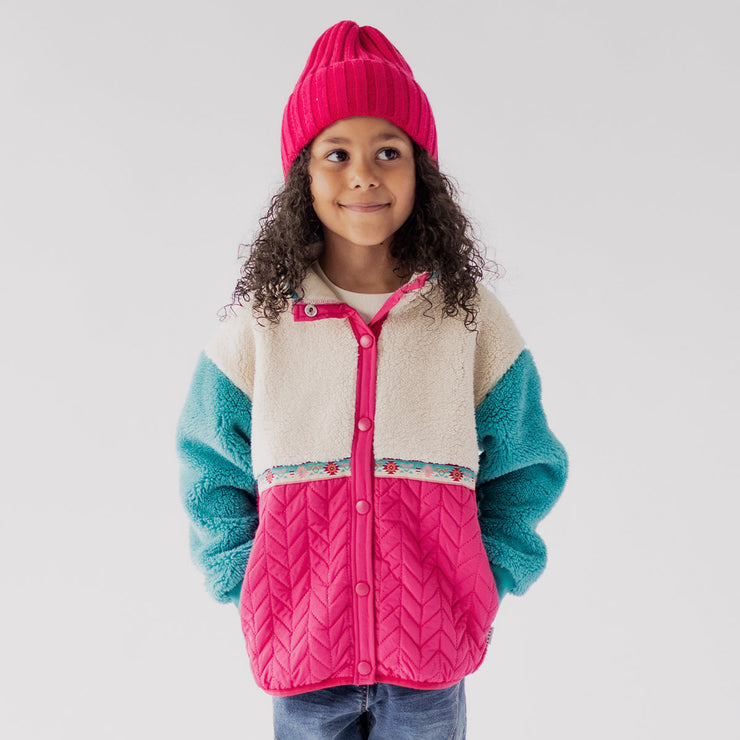 Photo d'un enfant portant la veste rose et turquoise en peluche, enfant