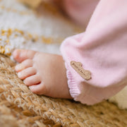 Une pièce rose en tricot avec motifs, naissance
