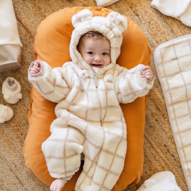 Photo d'un bébé portant le une pièce crème en sherpa, naissance