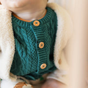 Photo d'un bébé portant le cardigan bleu sarcelle en tricot, naissance