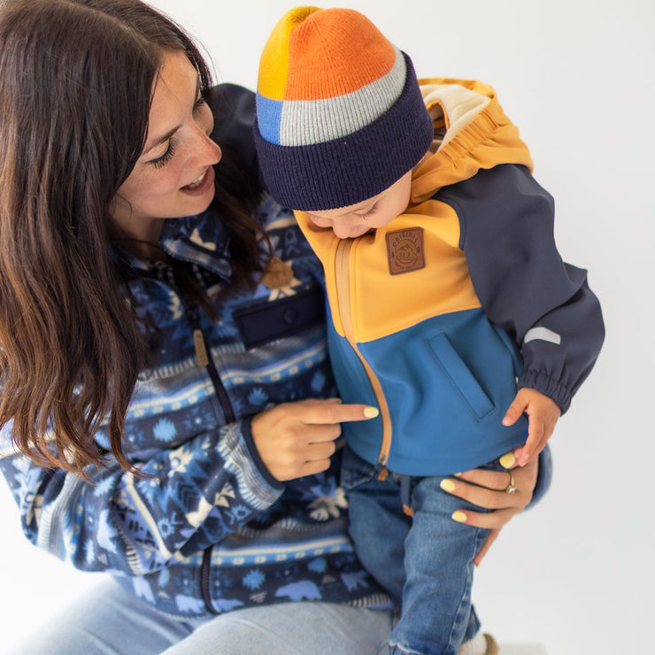 Photo d'un enfant portant le manteau bleu et jaune en coquille souple, bébé
