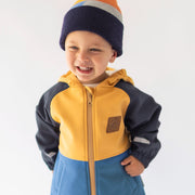 Photo d'un enfant portant le manteau bleu et jaune en coquille souple, bébé