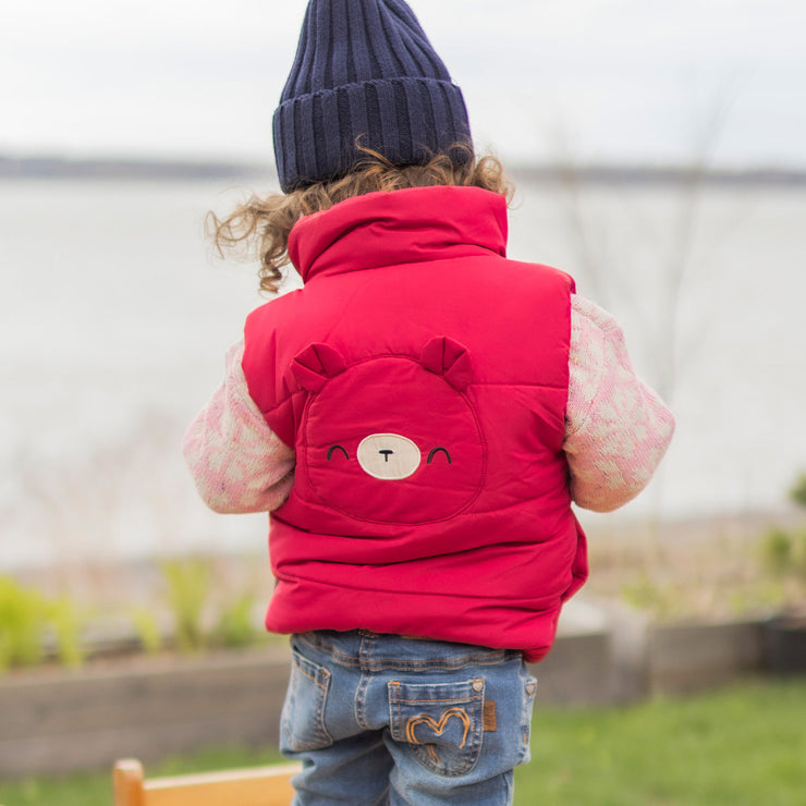 Photo d'un bébé de dos portant la veste doudoune sans manches rouge framboise, bébé