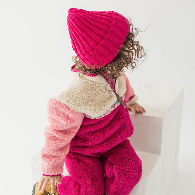Photo d'un bébé portant le une pièce rose en peluche, bébé