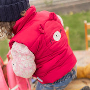 Photo de dos d'un bébé portant la veste doudoune sans manches rouge framboise, bébé