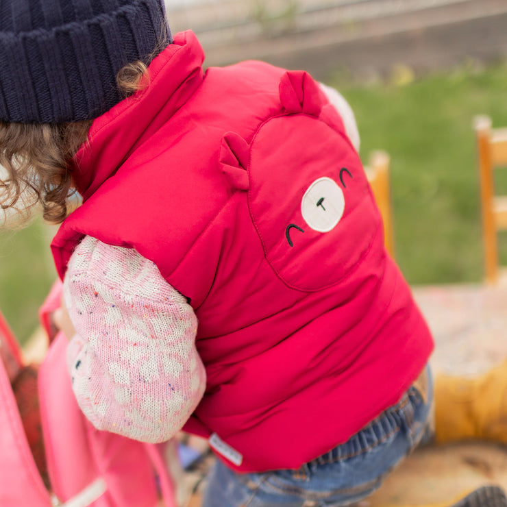 Photo de dos d'un bébé portant la veste doudoune sans manches rouge framboise, bébé