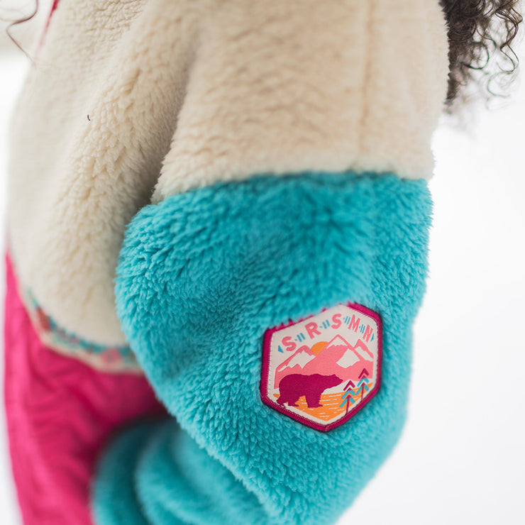 Zoom détails de la veste rose et turquoise en peluche, enfant