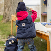 Photo de dos d'un bébé portant la veste doudoune sans manches bleu marine, bébé