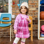 Photo d'un enfant portant la robe chasuble mauve à carreaux, bébé