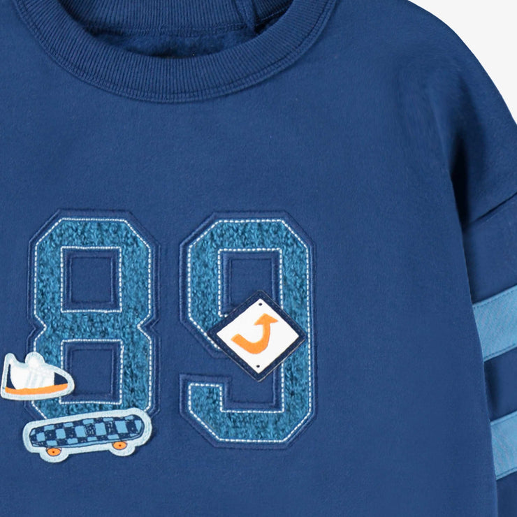 Zoom détails du chandail bleu avec broderie, enfant