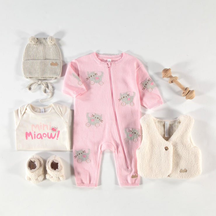 Une pièce rose en tricot avec motifs, naissance